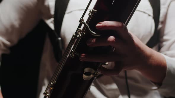 Closeup Fingers of Musician Playing Classical Music on Bassoon in Studio