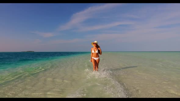 Female model sunbathing on exotic bay beach lifestyle by blue lagoon with white sand background of t