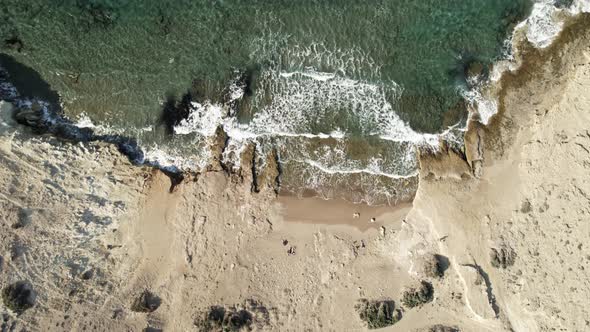 Sparkling, crystal-clear waves gently roll onto lonely beach in Greece. Summertime Milos Greece 4k.