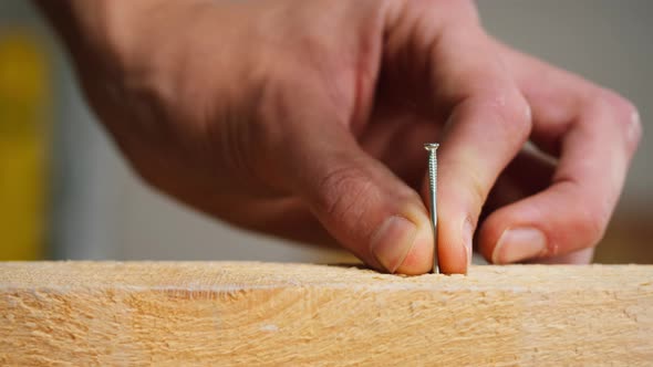 Man Builder Hammering Nails Into Wood Closeup Using Hammer