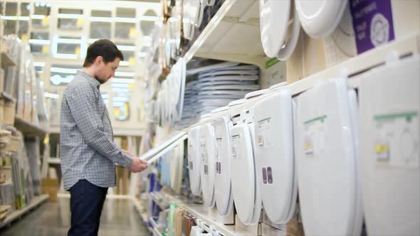 Man Selecting Toilet Seat in the Home Improvement Store