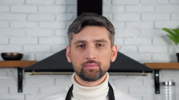 Male online chef standing at kitchen background, distance preparing cook food