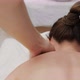 Female therapist massages a young woman on the neck and shoulders. Relaxing massage. - VideoHive Item for Sale