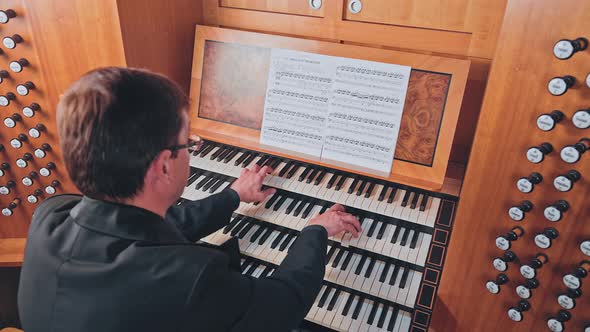 Organist Plays Music on Church Organ