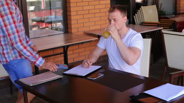 A male customer pays using NFC contactless payment technology on a smartphone.