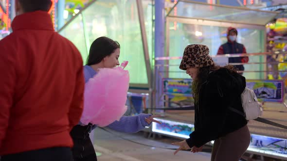 Two Teenage Girls Playing Paper Rock Scissors Game Outdoor in Valencia Funfair at Night