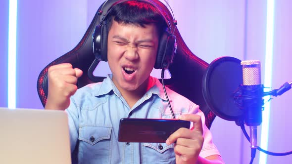 Asian Kid Boy Playing Video Game With Mobile Phone Then Celebrating While Live Stream