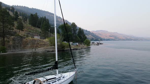 4k aerial shot over Okanagan lake flying backwards and passing sailing boats very closely in Vernon,