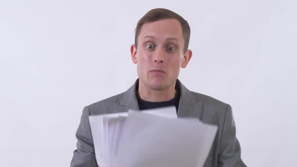 Portrait of Angry Man in Suit Shouts Holding Documents in Hands