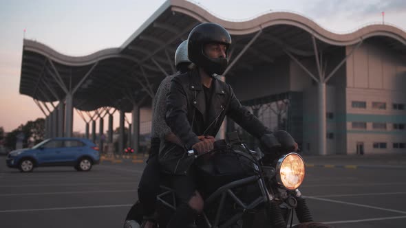 Young Couple in Helmets Riding on Motorcycle in City During Sunset Slow Motion