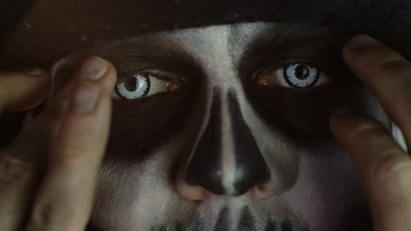 Close-up Man Face in Skeleton Halloween Cosplay Removing Hands From Face and Looking Wide Open Eyes