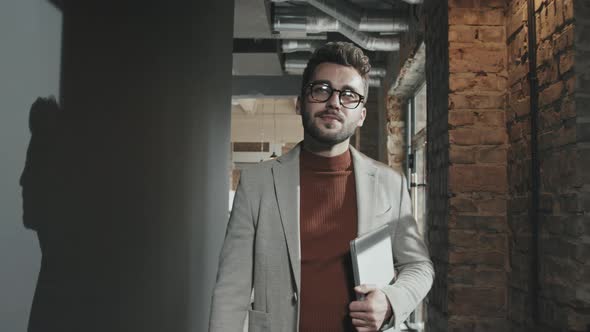 Handsome Bearded Businessman Walking through Coworking Office