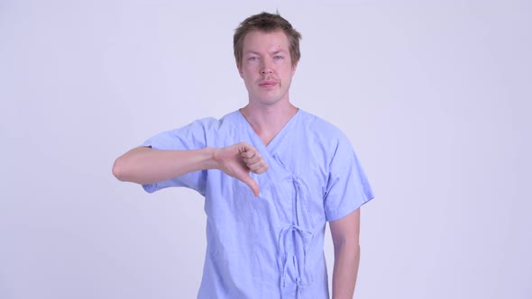 Portrait of Young Stressed Man Patient Giving Thumbs Down