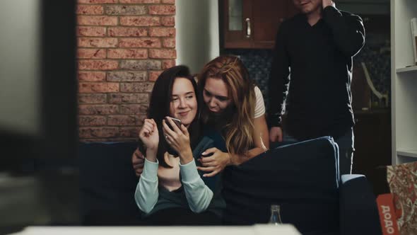 Girl Sitting on Couch Looking at Phone Screen