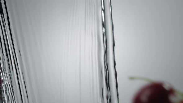 Ripe Cherry Fruits Thrown And Splashes Into Running Water On White Background. - close up, slow moti