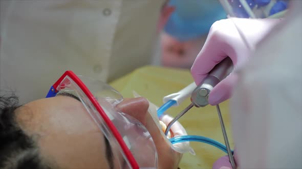 Woman Dentist Treating Teeth To Woman Patient in Clinic. Female Professional Doctor Stomatologist at