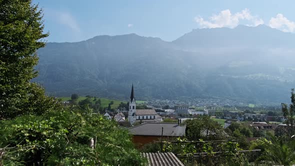 Panoramic View Liechtenstein with Houses on Green Fields in Alps Mountain Valley