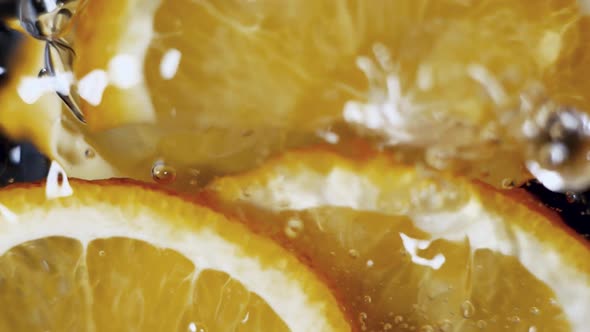 Orange Slices are Falling Into a Water in Slow Motion