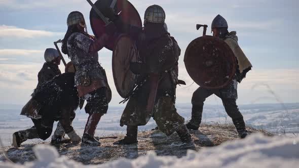 Warriors of vikings are fighting during attack at winter time.