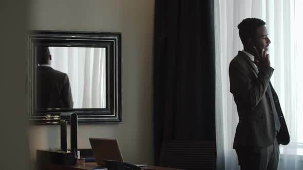 Businessman Talking on Phone in Hotel Room