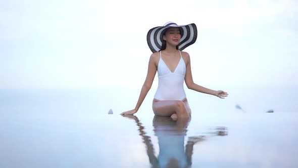 Young asian woman enjoy around outdoor swimming pool for leisure