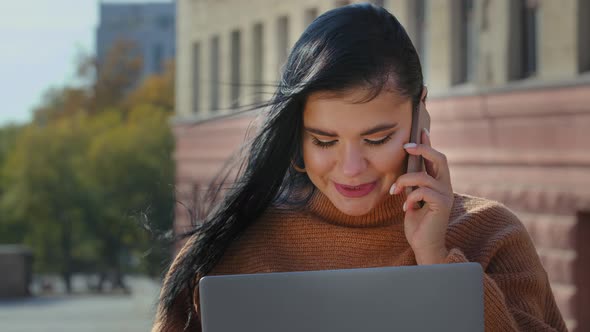 Female Portrait Young Hispanic Multitasking Girl Sitting Outdoors Looking at Laptop Screen Talking