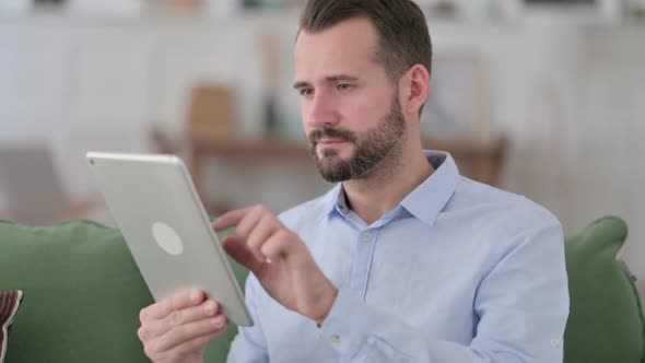 Young Man Celebrating Success on Tablet