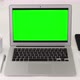 Laptop with mock-up green screen on a white table with house plants in home office. - VideoHive Item for Sale