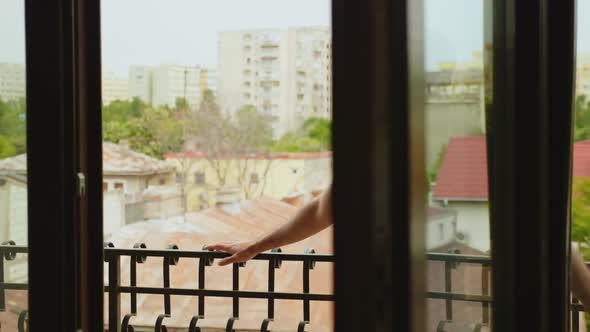 Revealing Shot of Man Relaxing on Balcony