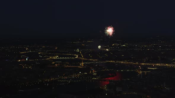 Multicolored Fireworks Over the Night City with Reflection in the Rivers