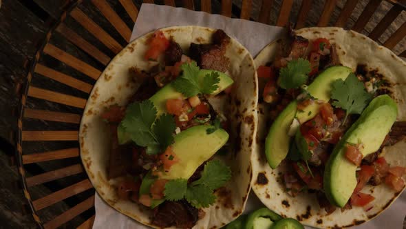 Rotating shot of delicious tacos on a wooden surface