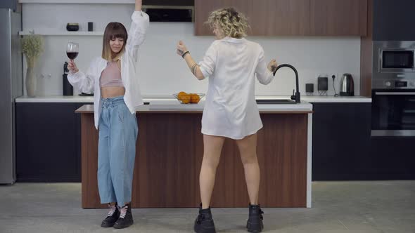 Wide Shot of Relaxed Happy LGBT Couple Having Fun Dancing in Kitchen at Home in Slow Motion