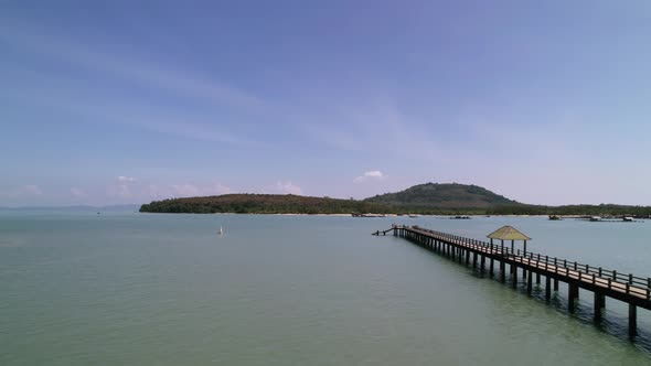 Laem Hin Pier in tropical andaman sea with coconut island on horizon in thailand, aerial
