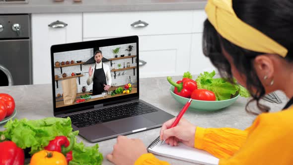 Man Chef in Laptop Screen Greets Tells Teaches Housewife Remote Cooking Lesson
