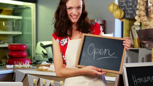 Portrait of a female staff holding a open sign