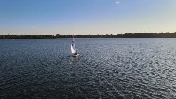 Aerial view of a sail boat going farther into the horizon