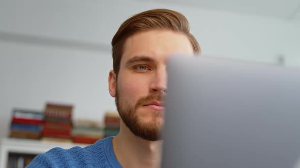 Young male surfing the internet using a laptop