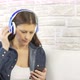 woman dressed in jeans dancing and listening music with headphones - VideoHive Item for Sale