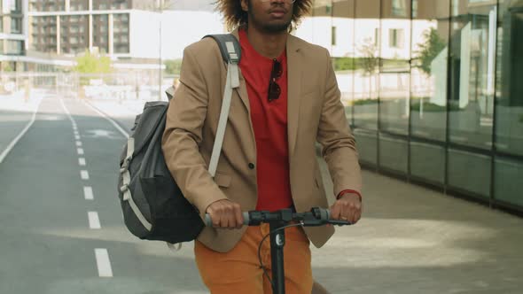 Afro-American Businessman Riding E-Scooter in Downtown