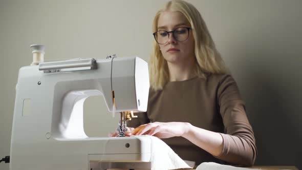 Seamstress Is Working Sewing Clothes in Sewing Machine Hands Closeup