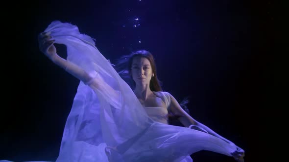 the Girl with the Long Hair Hovered in the Darkness Under the Water. She Moves Her Hands Beautifully