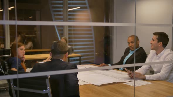 Business Team Sitting at a Table, Man with Virtual Reality Goggles. People Testing Vr Headset in