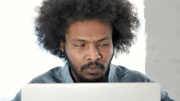 Close Up of Sick African Man Coughing and Working on Laptop