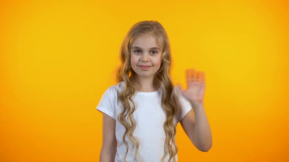 Beautiful Little Girl Waving Hello, Smiling Friendly to Camera, Happy Childhood