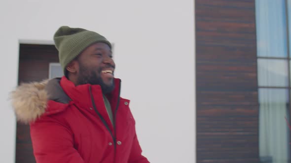 Joyous African American Man Playing Snowballs Outside