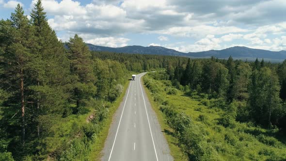 Top View of Truck Driving Along Highway in Forest Area