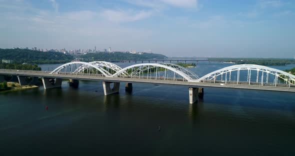 Aerial Top View of Automobile and Railroad Darnitsky Bridge Across Dnieper River from Above