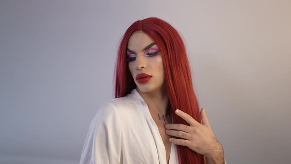 Front View Portrait Confident Proud Extravagant Transgender Woman Brushing Red Long Hair in Slow
