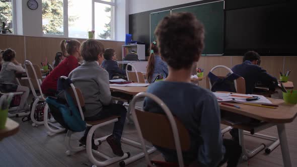 Students Listening To Teacher in Geography Lesson