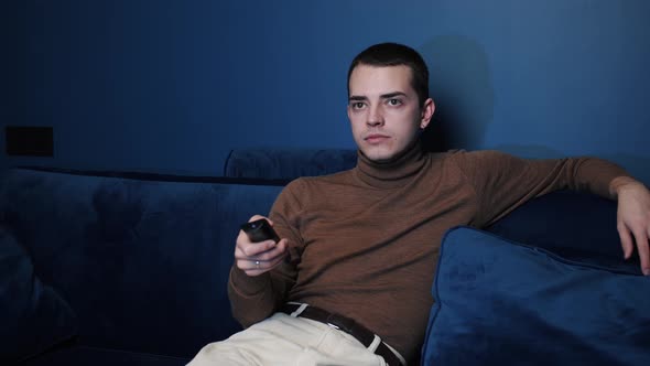 Man Enjoy Weekends Resting Lean Sit on Comfy Sofa in Living Room Alone, Hold Remote Control Switch